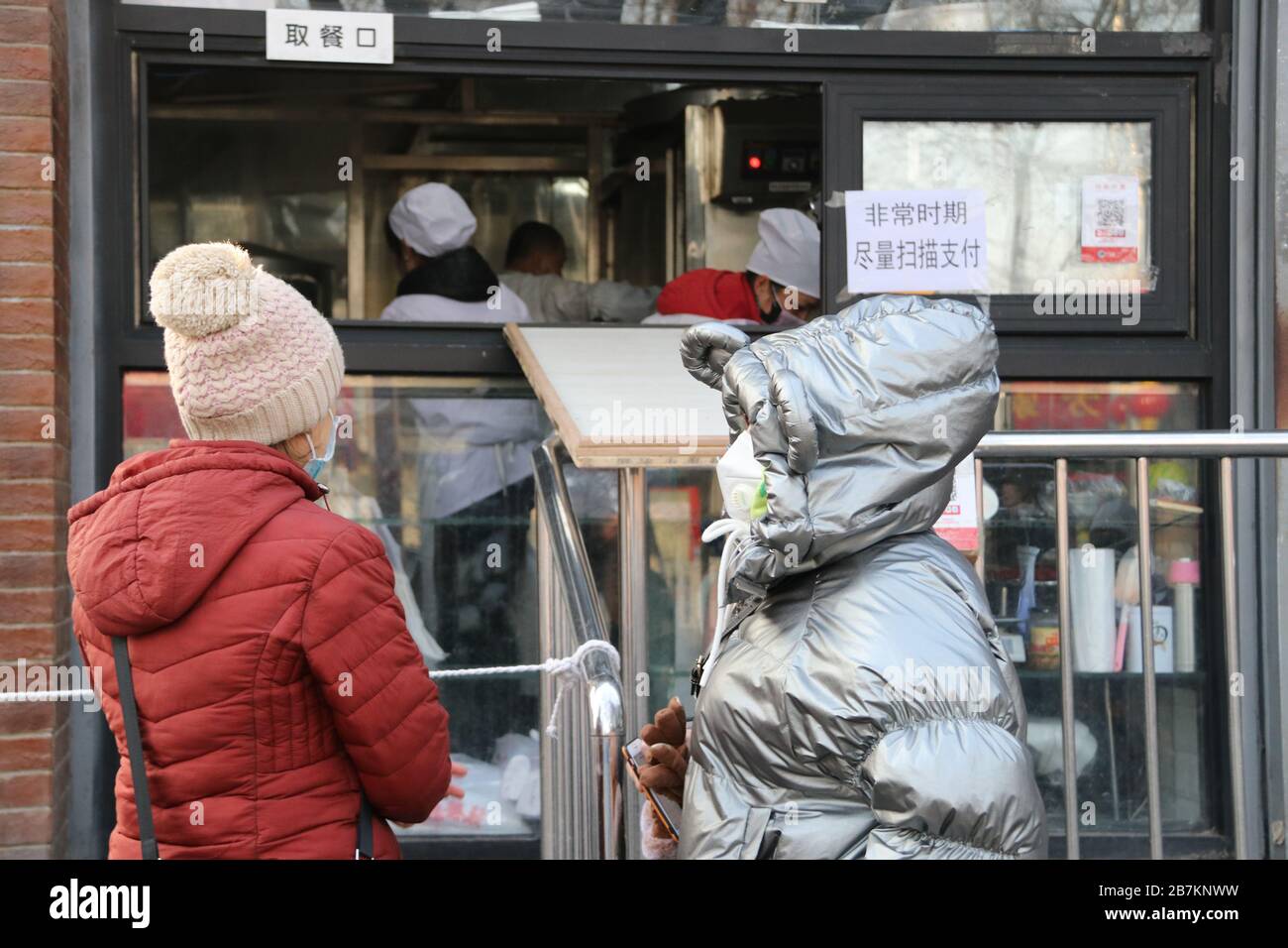 Un negozio di bun al vapore crea 'no touch selling' utilizzando un asse per consegnare buns e codice QR per raccogliere la tassa per evitare la trasmissione di virus, Pechino Foto Stock
