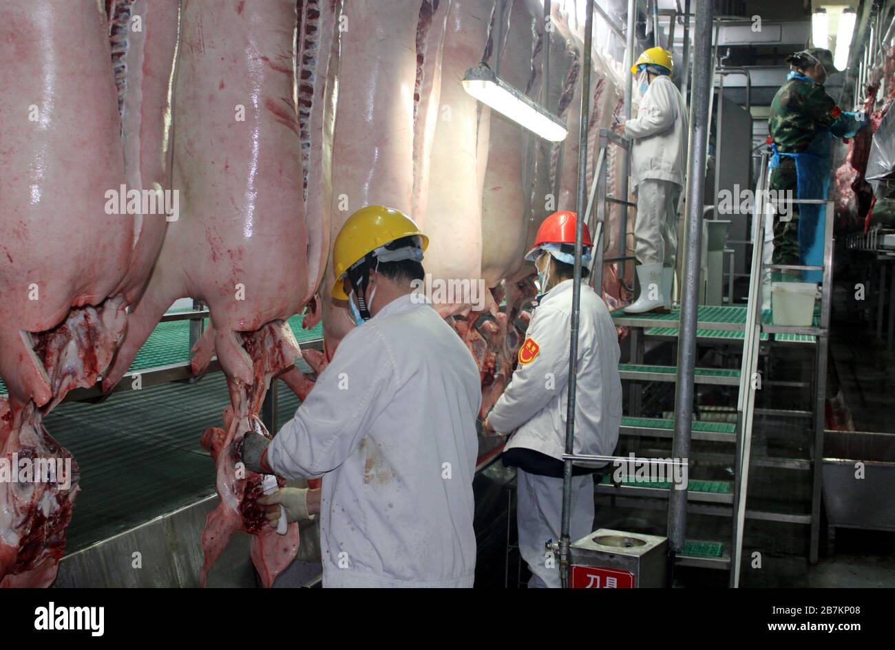 Il personale di una fabbrica di trasformazione alimentare di proprietà del Gruppo Shuanghui, un'azienda cinese famosa per la sua salsiccia, è impegnato al lavoro per garantire il mea nazionale Foto Stock