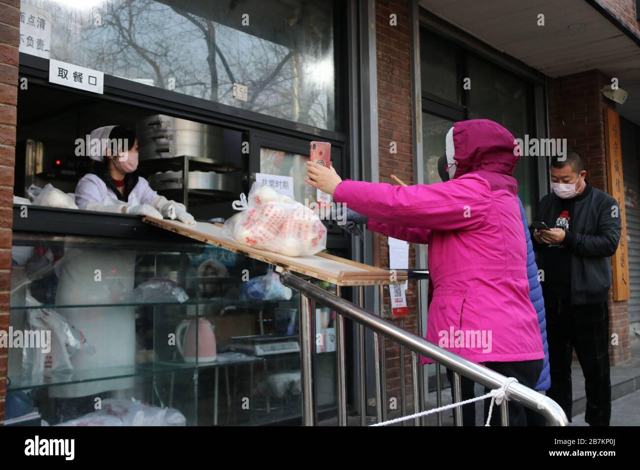 Un negozio di bun al vapore crea 'no touch selling' utilizzando un asse per consegnare buns e codice QR per raccogliere la tassa per evitare la trasmissione di virus, Pechino Foto Stock