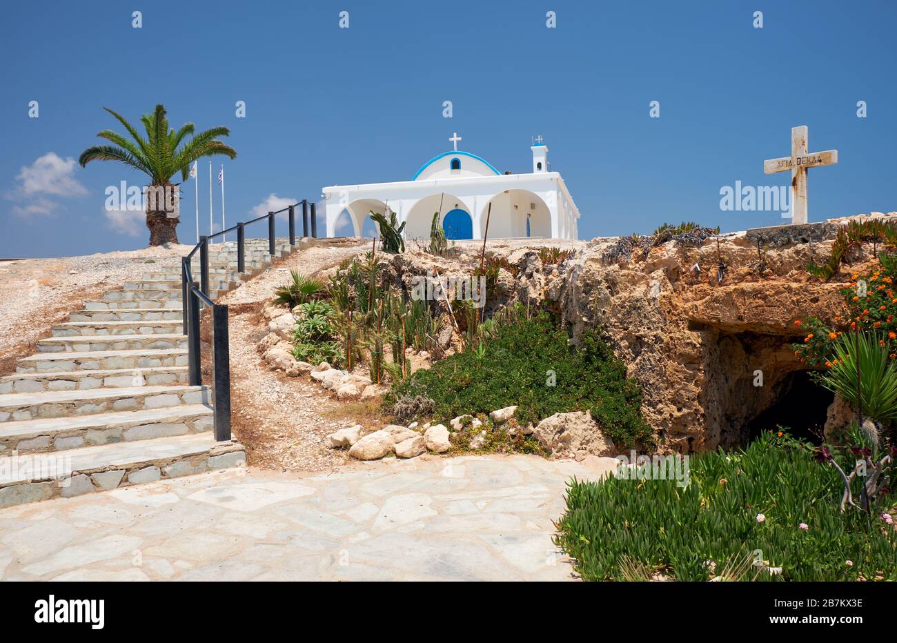 La piccola vecchia chiesa catacomba di San Thekla (Agia Thekla) e la bella nuova sulla sporgenza rocciosa che sale le scale. Ayia Napa. Cipro Foto Stock