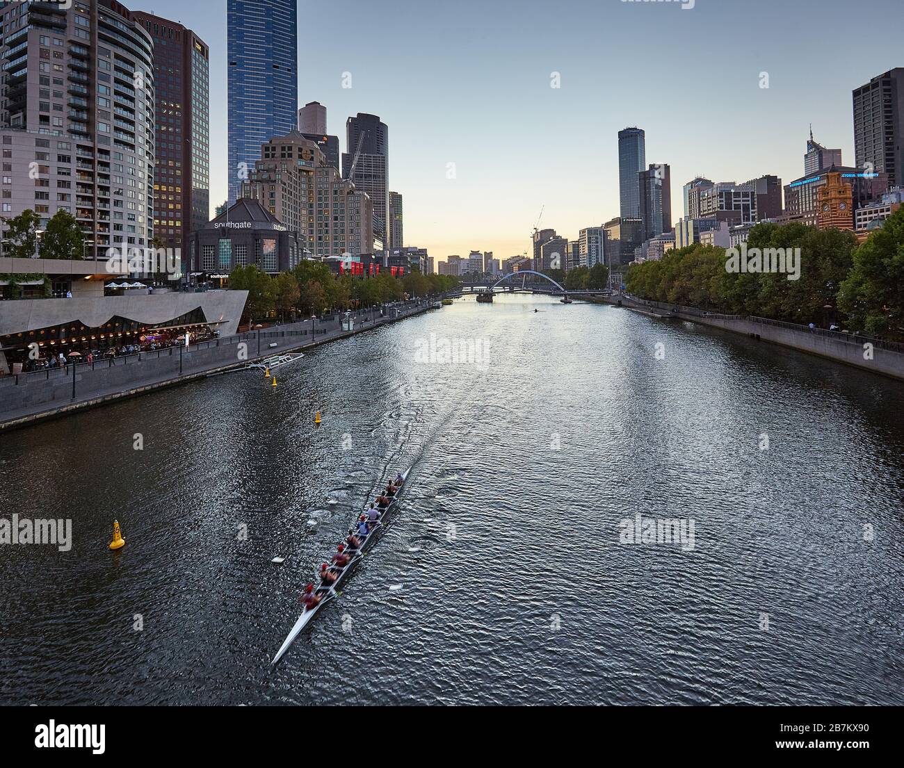 Vogatori sul fiume Yarra nel CBD di Melbourne al crepuscolo Foto Stock