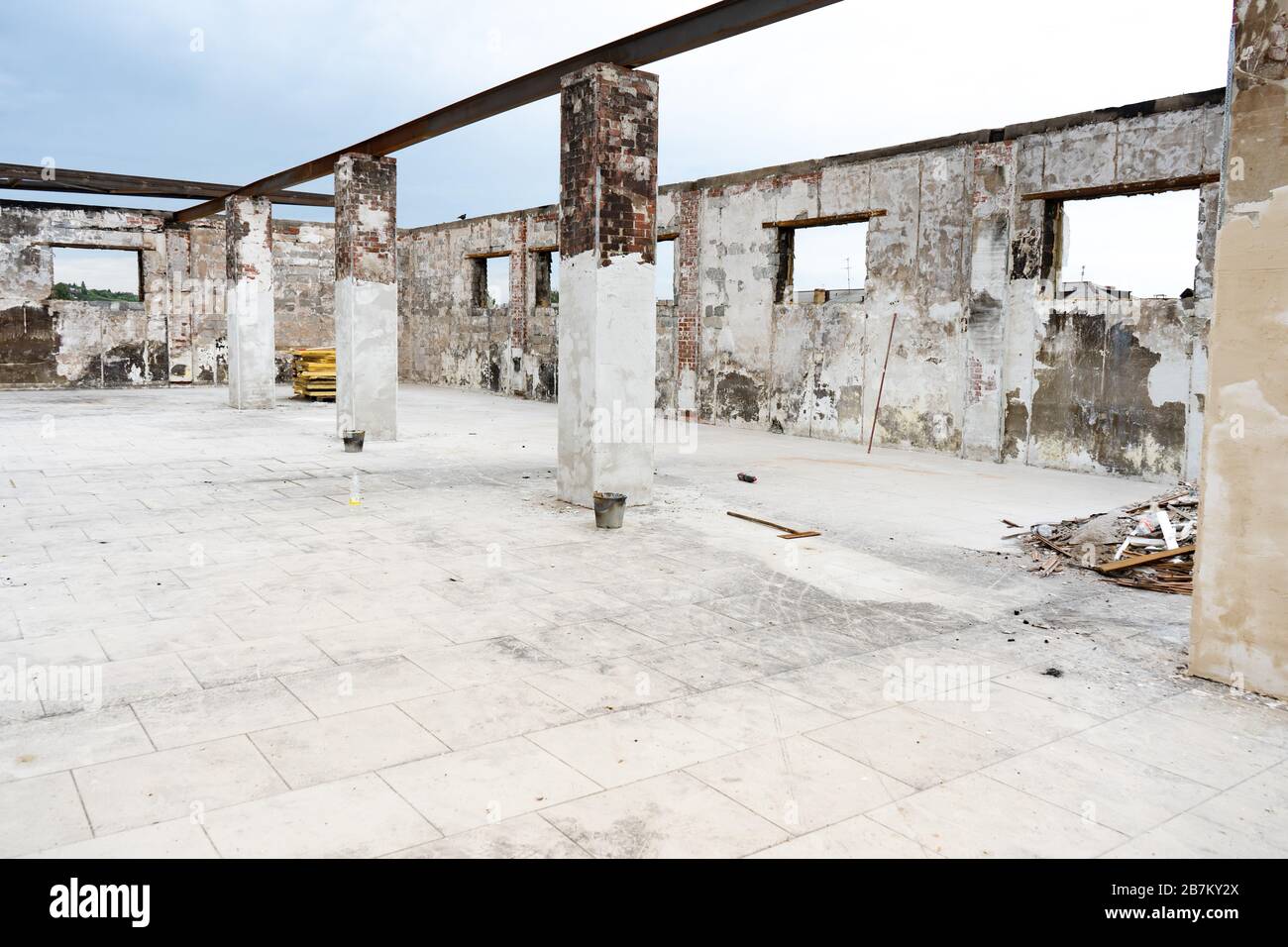 Magazzino abbandonato con colonne senza tetto. Grande sala industriale. Grande camera vecchia abbandonata Foto Stock