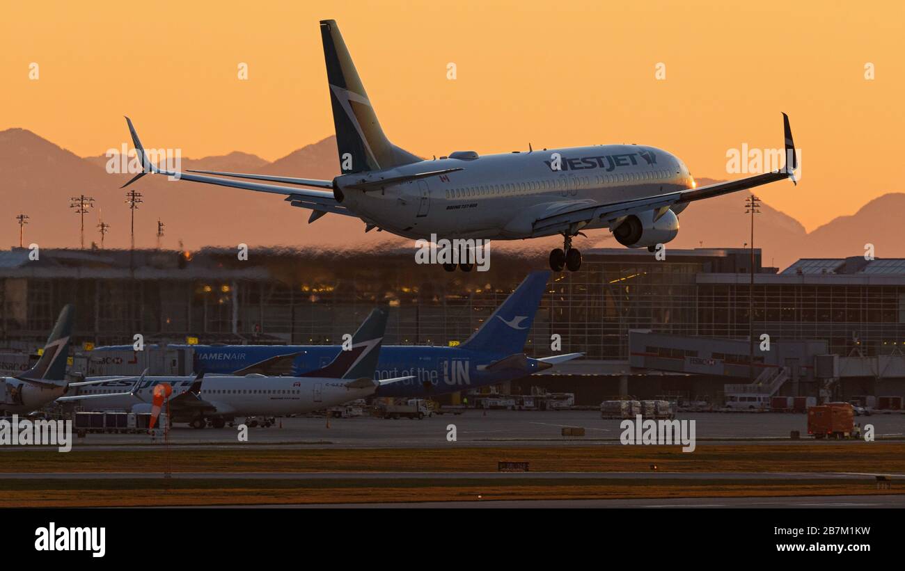 Richmond, British Columbia, Canada. 16 Marzo 2020. Un jet WestJet Airlines Boeing 737-800 atterra al tramonto, all'Aeroporto Internazionale di Vancouver, Richmond, B.C., Canada, lunedì 16 marzo 2020. All'inizio del giorno il governo canadese, nel tentativo di fermare la diffusione del romanzo coronavirus, ha annunciato che i confini della nazione sarebbero stati chiusi a partire da mercoledì 18 marzo a tutti i viaggiatori diversi dai cittadini canadesi e residenti permanenti, cittadini statunitensi, diplomatici e lavoratori essenziali. Credit: Bayne Stanley/ZUMA Wire/Alamy Live News Foto Stock