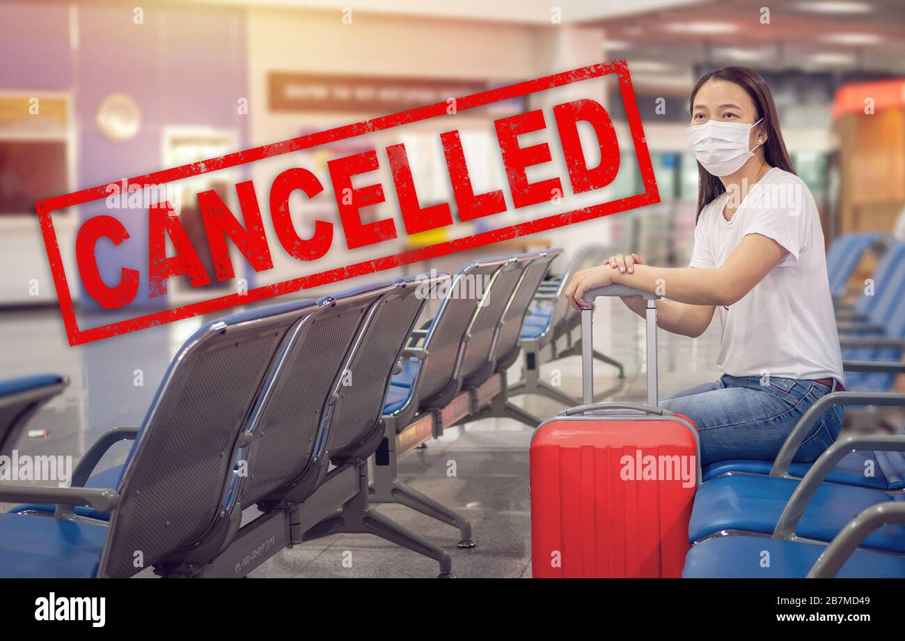 cancellazione del volo. Turista asiatico con bagagli, indossare maschera igienica per evitare il tempo di viaggio al terminal dell'aeroporto per proteggere da Coronavirus Foto Stock