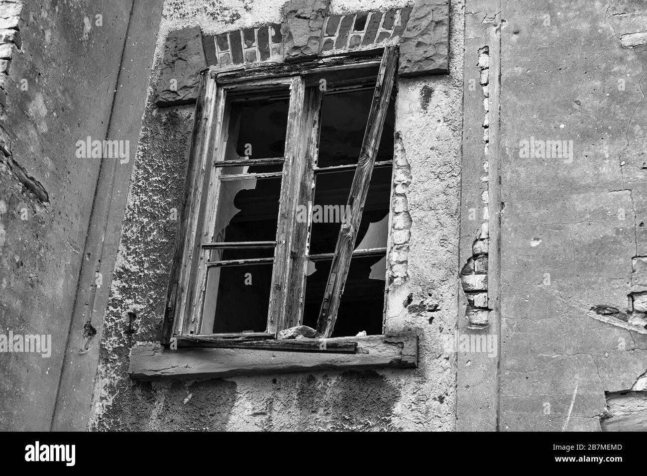 Dettaglio di una finestra spezzata in un edificio abbandonato nel Vecchio Porto di Trieste, Friuli-Venezia-Giulia, Italia: Versione in bianco e nero Foto Stock