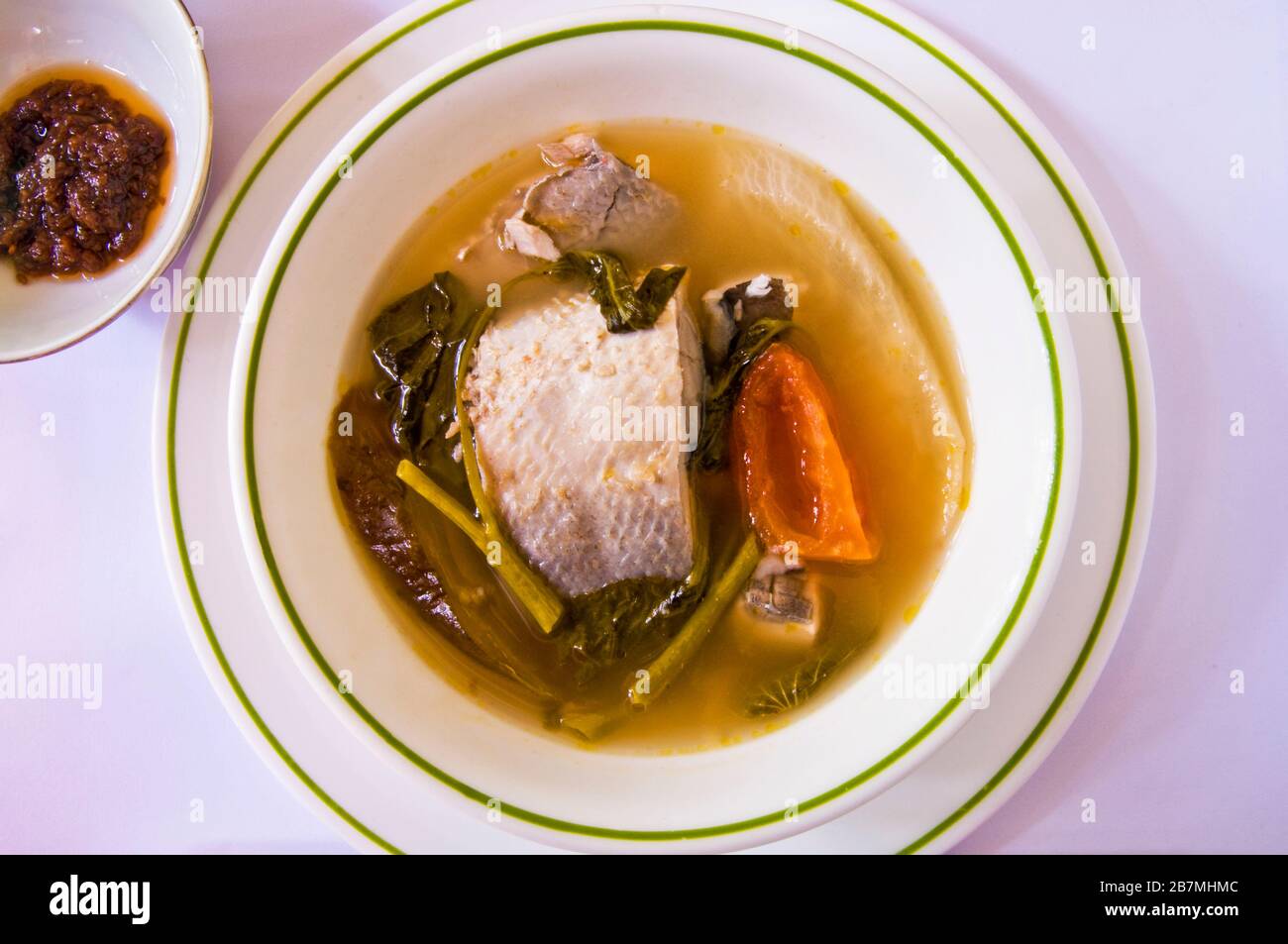 La milkfish in brodo tamarindo è un piatto filippino che di solito mangiato con riso. È saporito e saporito. Foto Stock