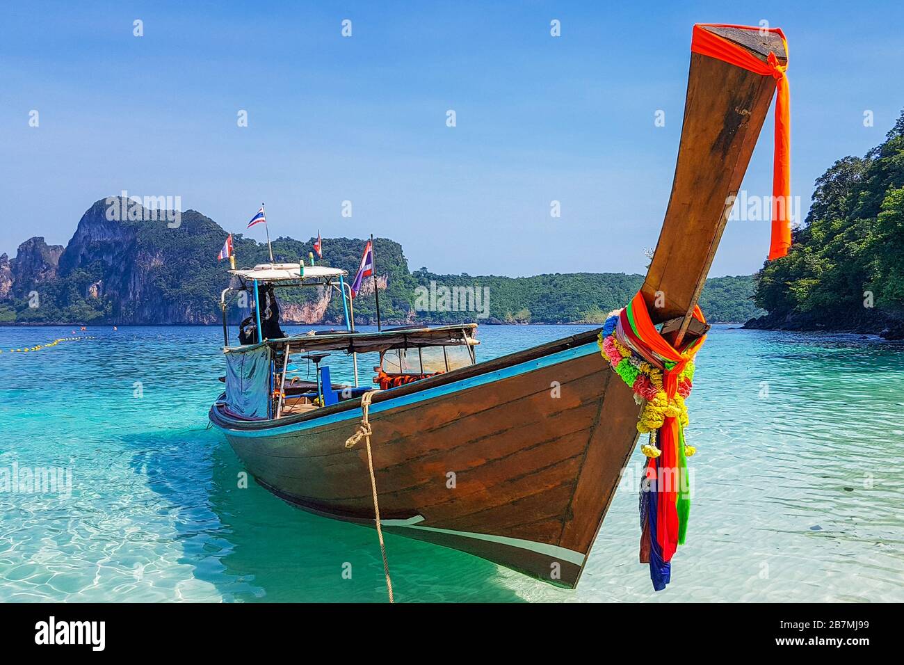 Barca a coda lunga sulla spiaggia delle scimmie a Koh Phi Phi Foto Stock