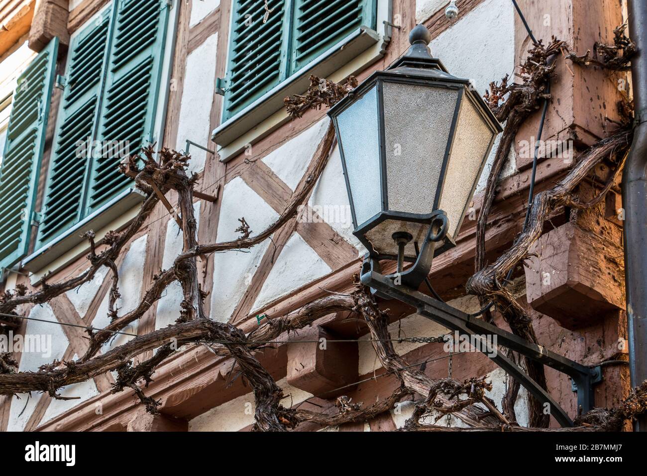 Grande lampada su un vecchio edificio storico e persiane verdi Foto Stock