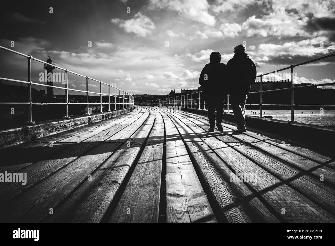 Persone su un molo in una giornata di sole, Whitby, North Yorkshire Foto Stock