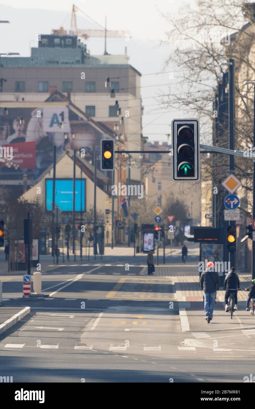 Lubiana, Slovenia - 17 marzo 2020: Semafori funzionanti nel centro di Lubiana, Slovenia, su strade quasi vuote con pochi ciclisti e pedalini Foto Stock