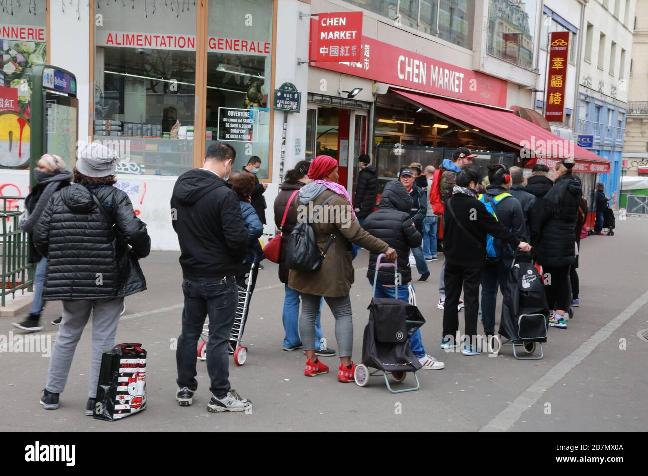 17 marzo 2020: Parigi, Francia molte persone si allineano per entrare nei supermercati in un quartiere asiatico, Belleville, prima che il governo francese rimanga a. Foto Stock