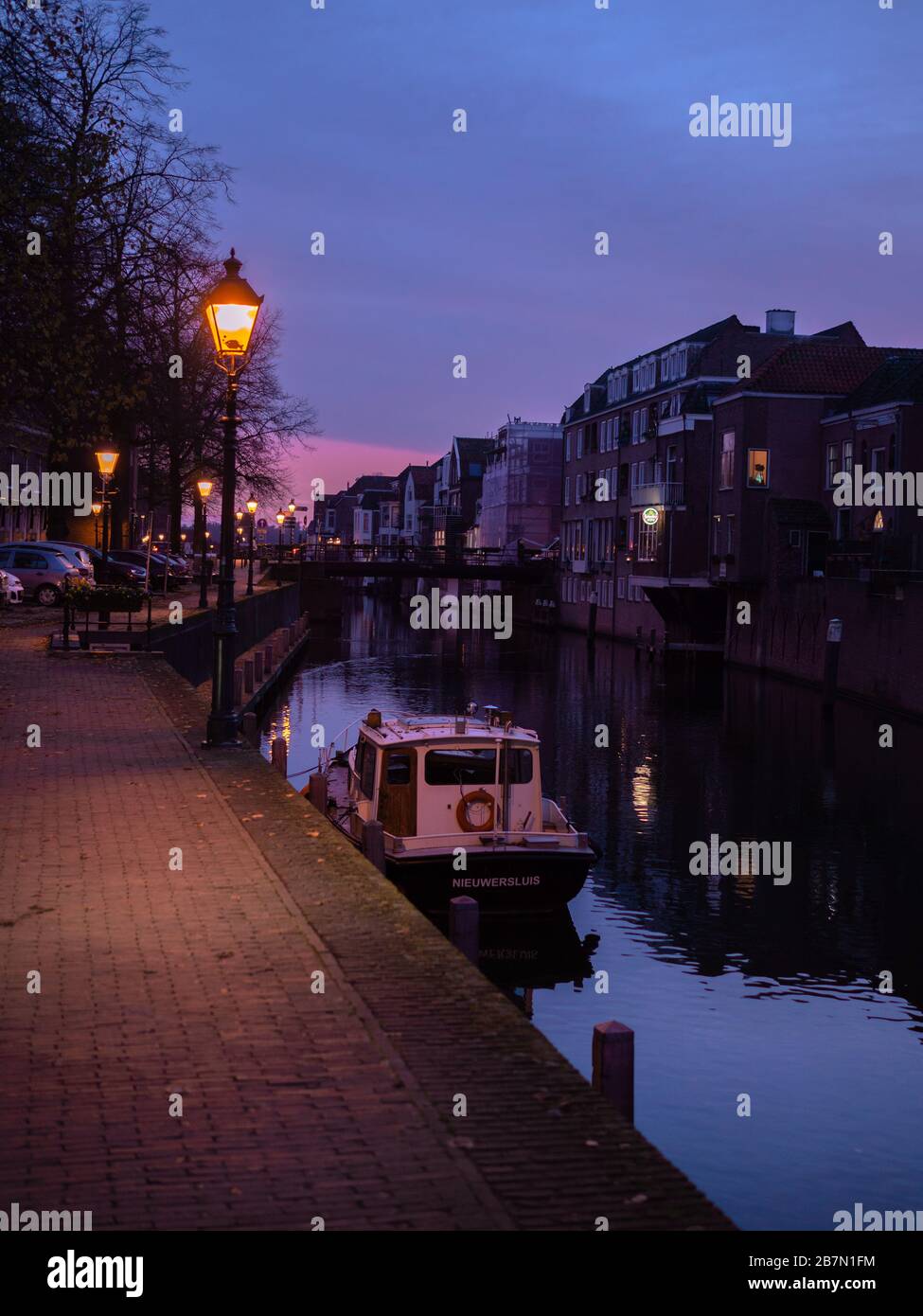 Barca in una città silenziosa con cielo viola Foto Stock
