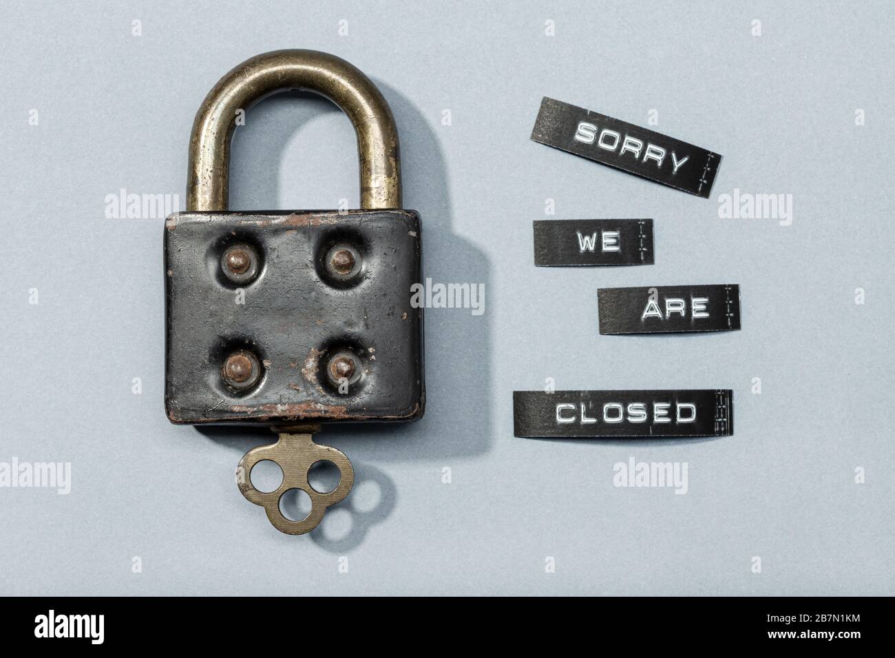 Lucchetto con etichetta ci dispiace siamo chiusi isolati su sfondo grigio. Chiuso da coronavirus o concetto covid-19 Foto Stock
