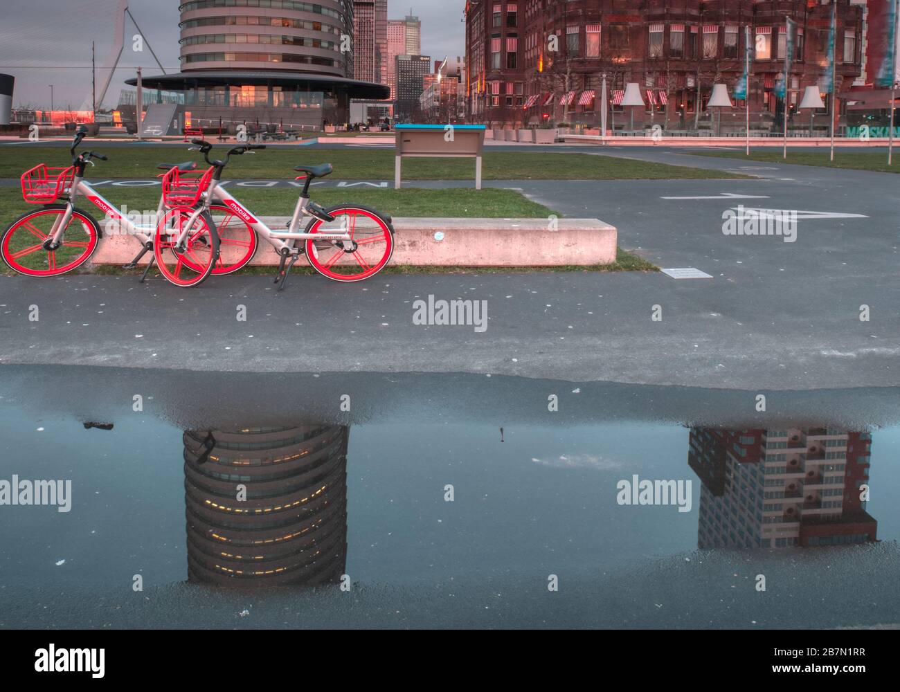 Rotterdam, Paesi Bassi - 12 febbraio 2019: Hotel New York, due biciclette rosse parcheggiate di fronte all'hotel, l'hotel e le biciclette riflesse Foto Stock