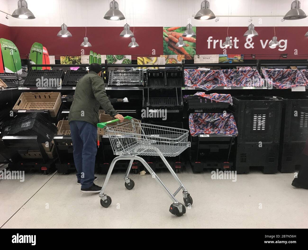 Scaffali quasi vuoti dove frutta e verdura sono di solito stoccati nel Sainsbury's a Clapham Junction, Londra, il giorno dopo che il primo ministro Boris Johnson ha invitato le persone a stare lontano da pub, club e teatri, lavorare da casa se possibile ed evitare tutti i contatti non essenziali e viaggiare per ridurre l'impatto della pandemia di coronavirus. Foto Stock