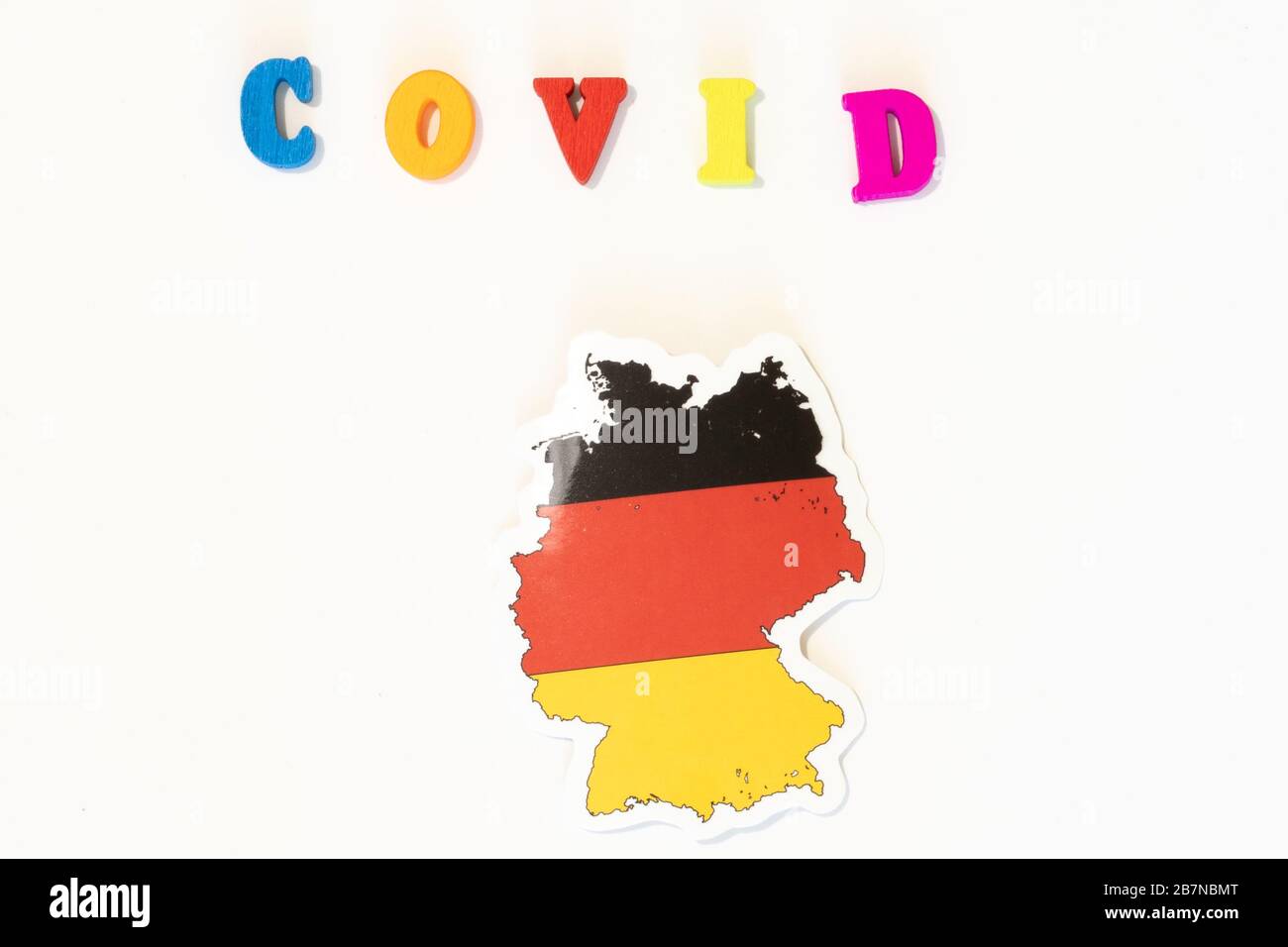 Bandiera nazionale tedesca su sfondo bianco con l'iscrizione Covid fatta con bacheca. Il coronavirus è un virus pandemico originario della Cina Foto Stock