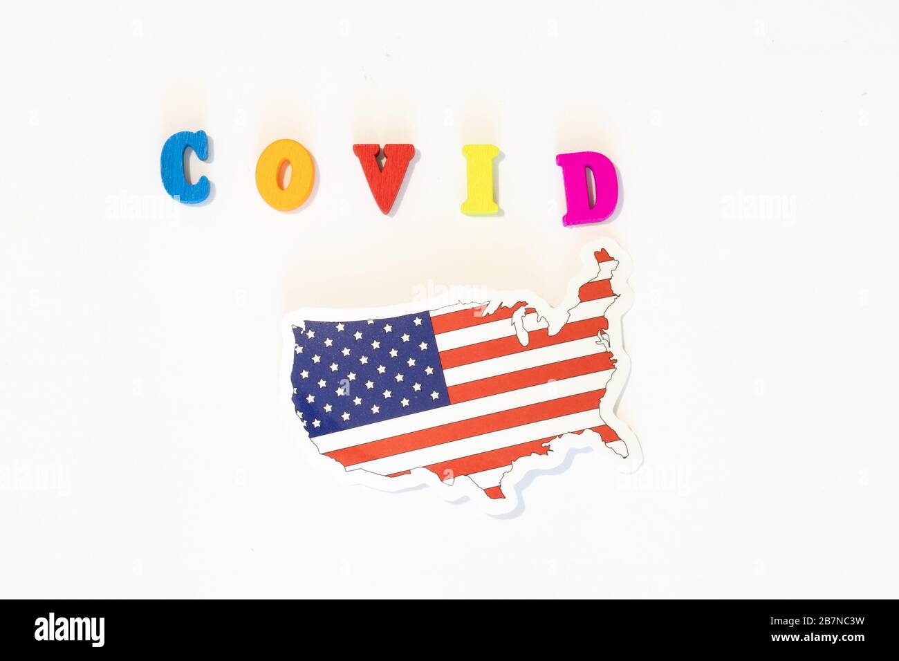 USA bandiera nazionale degli Stati Uniti su sfondo bianco con l'iscrizione Covid fatta con la bacheca delle lettere. Il coronavirus è un virus pandemico che origina Foto Stock