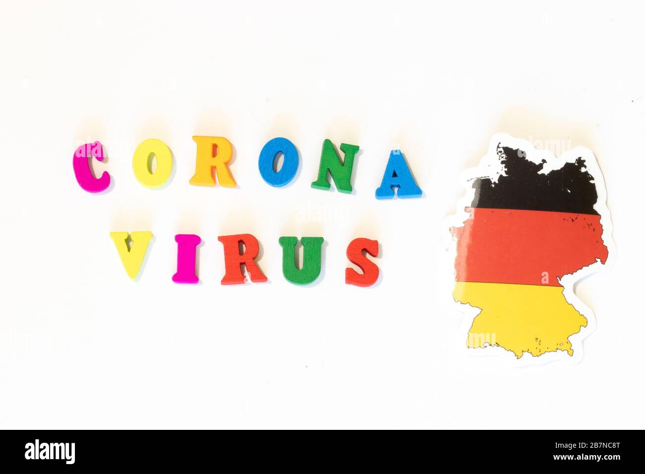 Germania bandiera nazionale su sfondo bianco con l'iscrizione Corona virus fatta con la bacheca delle lettere. Il coronavirus è un virus pandemico di origine Foto Stock