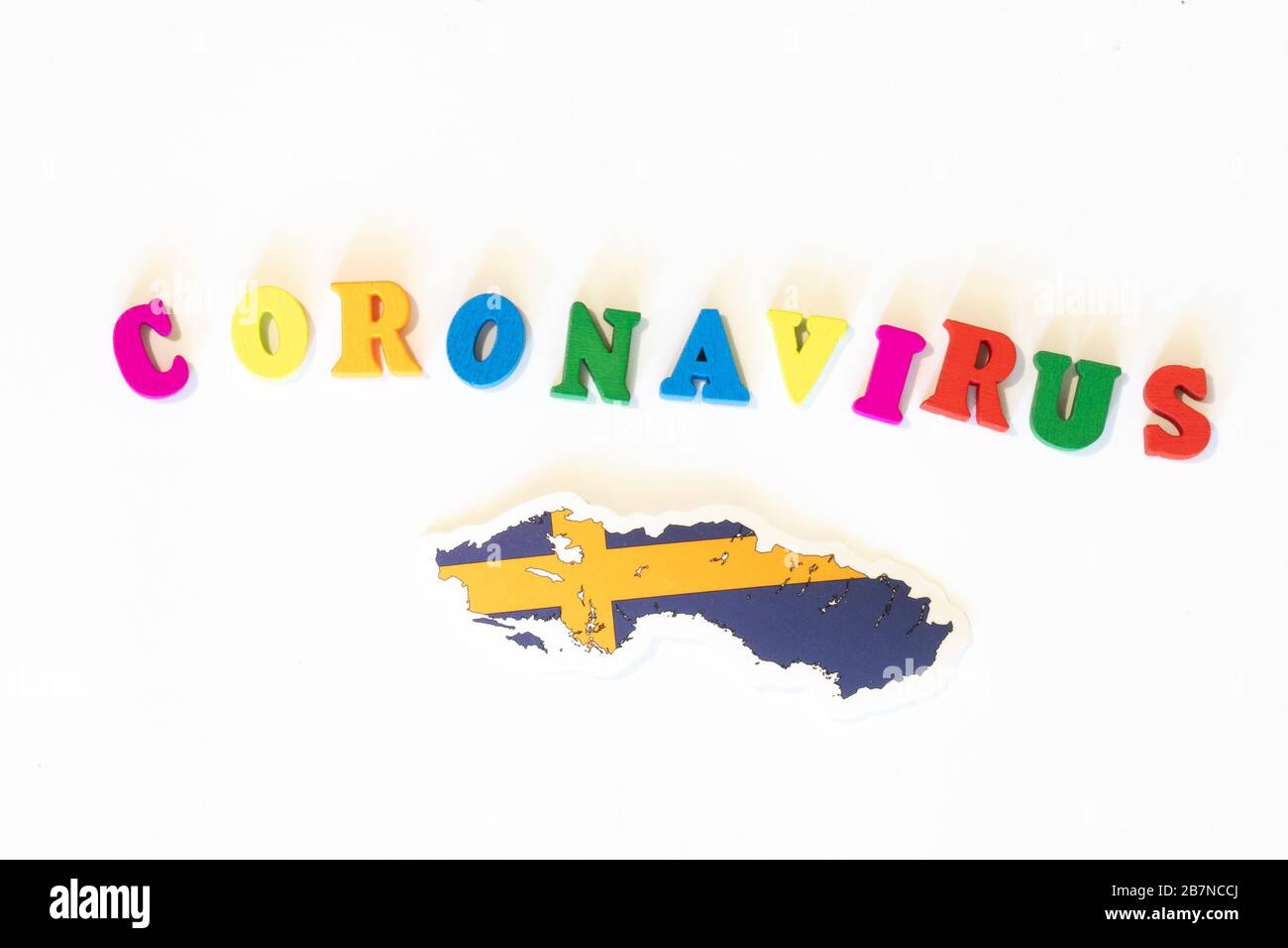 Bandiera nazionale svedese su sfondo bianco con l'iscrizione Corona virus fatta con letter board. Il coronavirus è un virus pandemico di origine Foto Stock