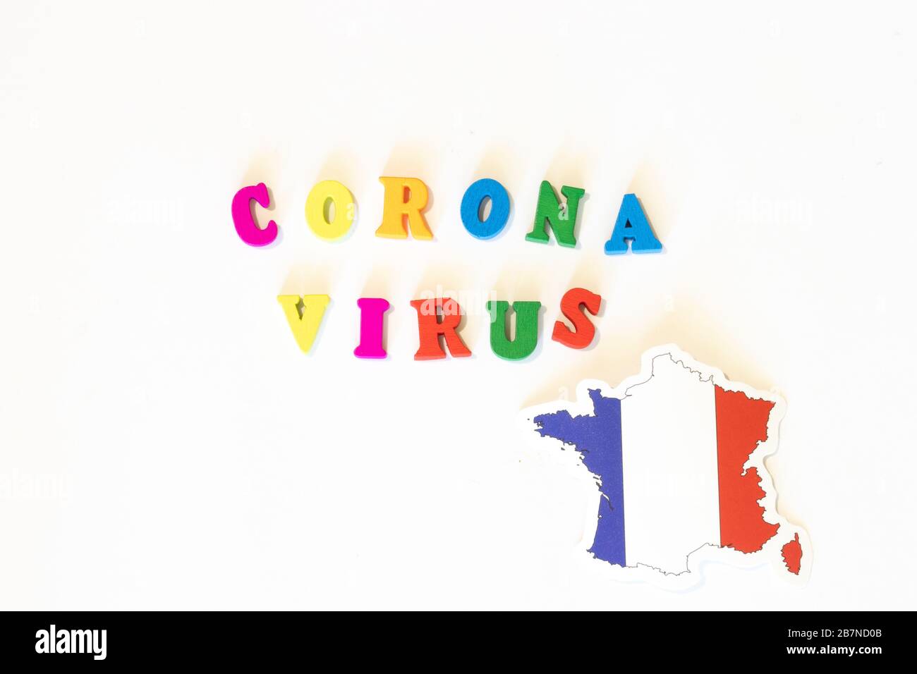 Francia bandiera nazionale su sfondo bianco con l'iscrizione Corona virus fatta con la bacheca delle lettere. Il coronavirus è un virus pandemico di origine Foto Stock