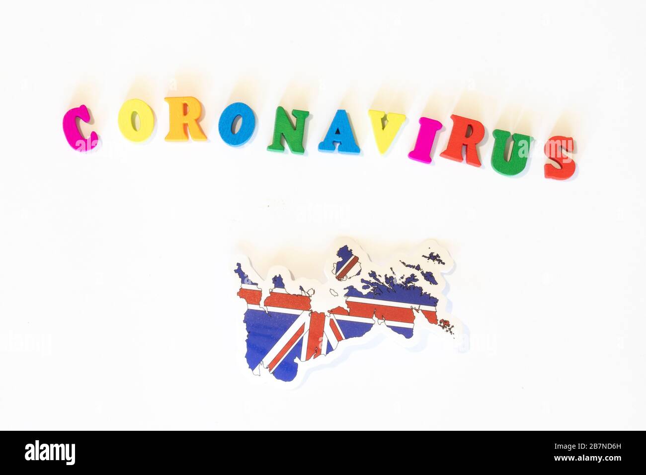 Regno Unito bandiera nazionale del Regno Unito su sfondo bianco con l'iscrizione Corona virus fatta con la bacheca delle lettere. Il coronavirus è un virus pandemico Foto Stock