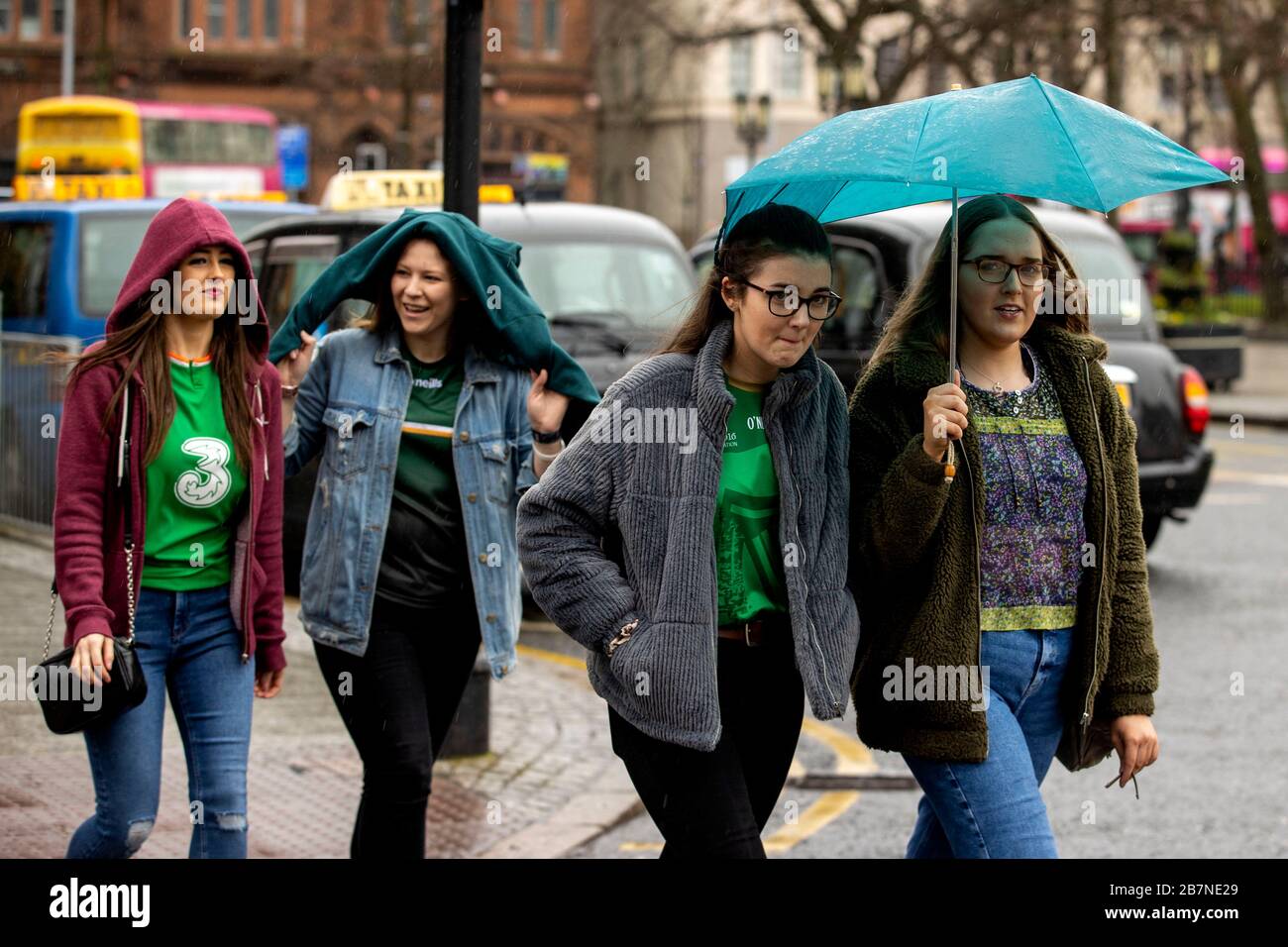 Un gruppo di giovani donne cammina attraverso Belfast durante il giorno di San Patrizio. A causa di Coronavirus Belfast City Council ha annullato i festeggiamenti per la sicurezza del pubblico. Foto Stock