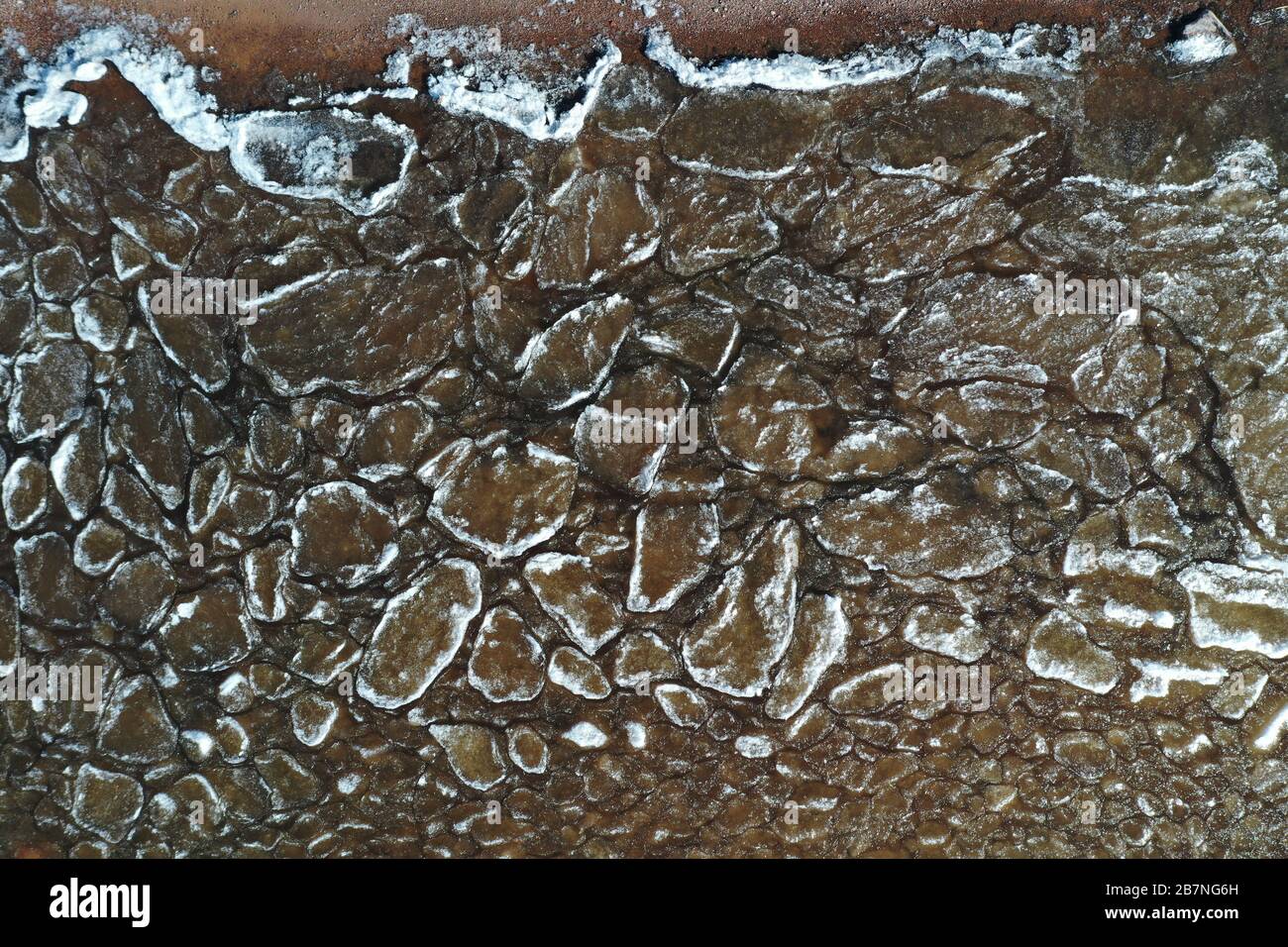 Pezzi di ghiaccio galleggiante sulle onde, placche di ghiaccio, costa sabbiosa, pietre, paesaggio primaverile, tempo soleggiato, pacificazione Foto Stock