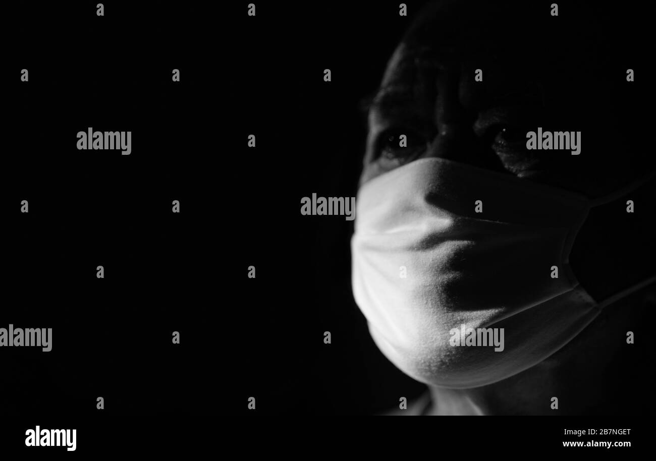 Ritratto di un uomo spaventato di Covid-19. Un uomo spaventato si trova in una maschera medica protettiva contro virus e infezioni. Maschera medica studio isolato. Coron Foto Stock