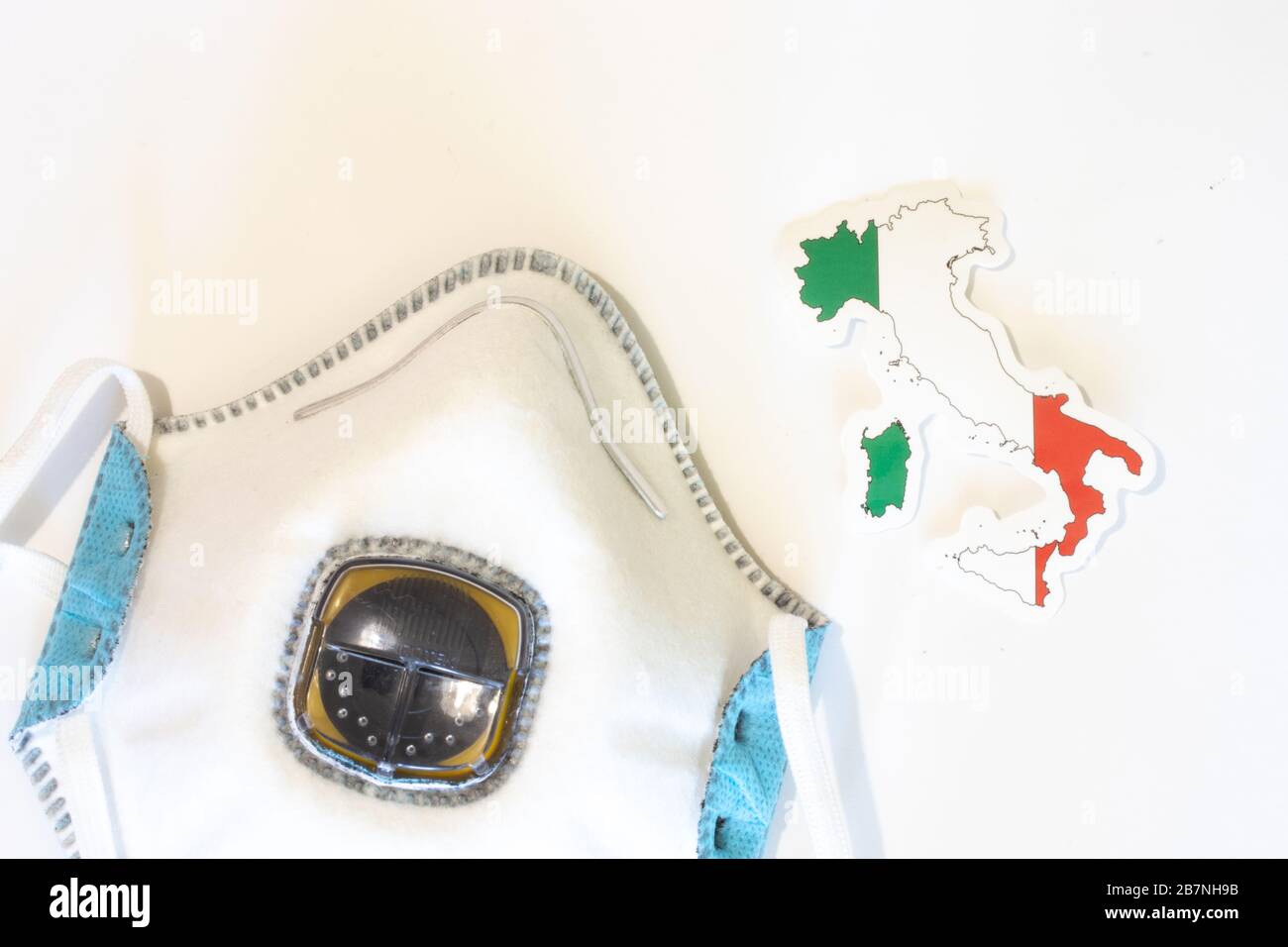 Respiratore con vista dall'alto della bandiera italiana. Piatto con respiratore per maschera medica per proteggere una persona da infezioni e virus. Assistenza sanitaria e. Foto Stock