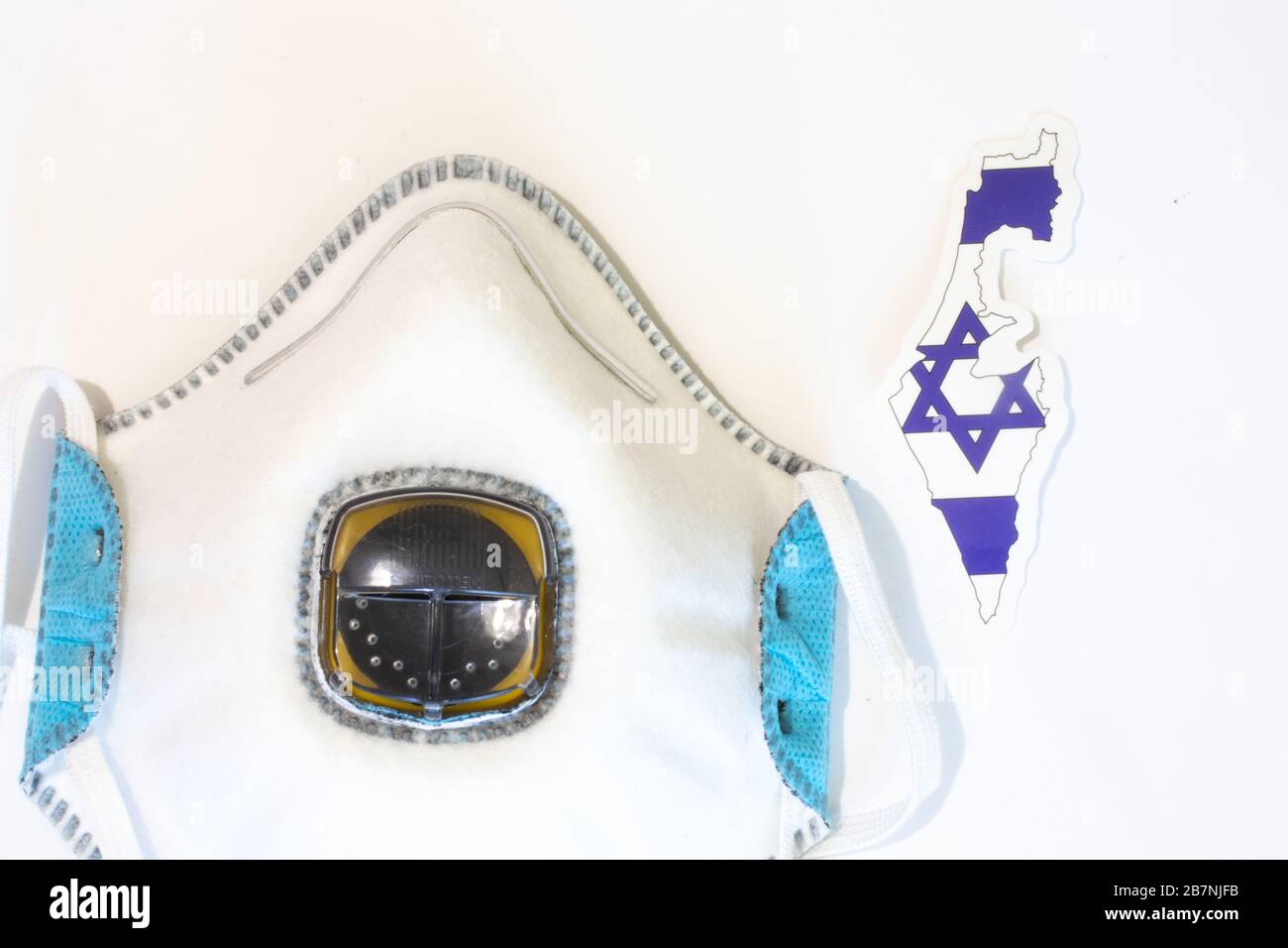 Respiratore con la bandiera di Israele vista dall'alto. Piatto con respiratore per maschera medica per proteggere una persona da infezioni e virus. Assistenza sanitaria e. Foto Stock