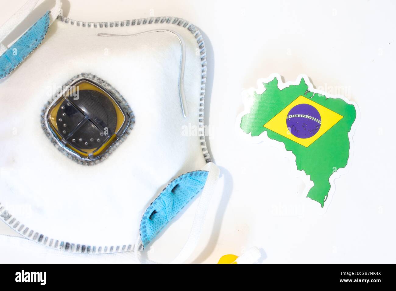 Respiratore con vista dall'alto della bandiera brasiliana. Piatto con respiratore per maschera medica per proteggere una persona da infezioni e virus. Assistenza sanitaria e. Foto Stock