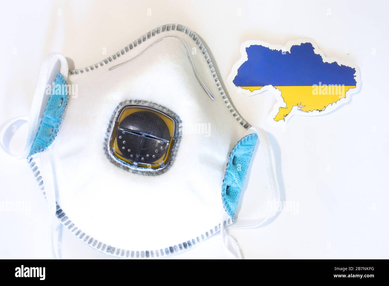 Respiratore con la bandiera Ucraina vista dall'alto. Piatto con respiratore per maschera medica per proteggere una persona da infezioni e virus. Assistenza sanitaria e. Foto Stock