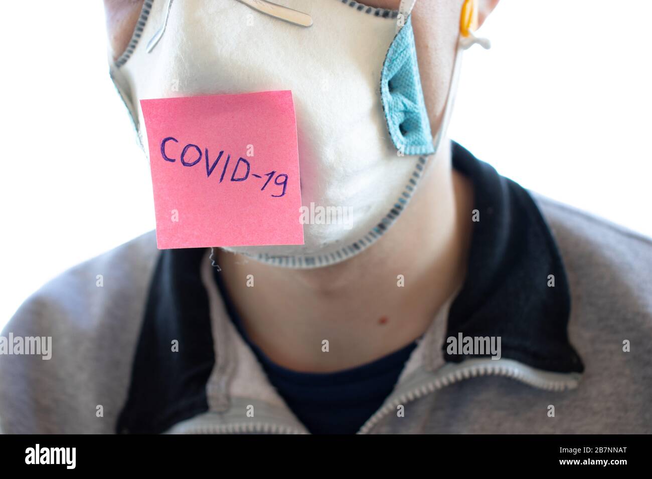 Uomo in maschera facciale respiratore e adesivo con Covid-19 parola sul viso. Il coronavirus è un virus pandemico originario della Cina. Protezione dalle malattie Foto Stock
