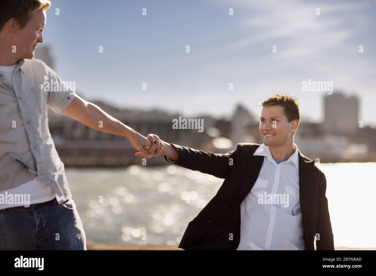 Due giovani omosessuali si guardano mentre si tengono le mani. Foto Stock