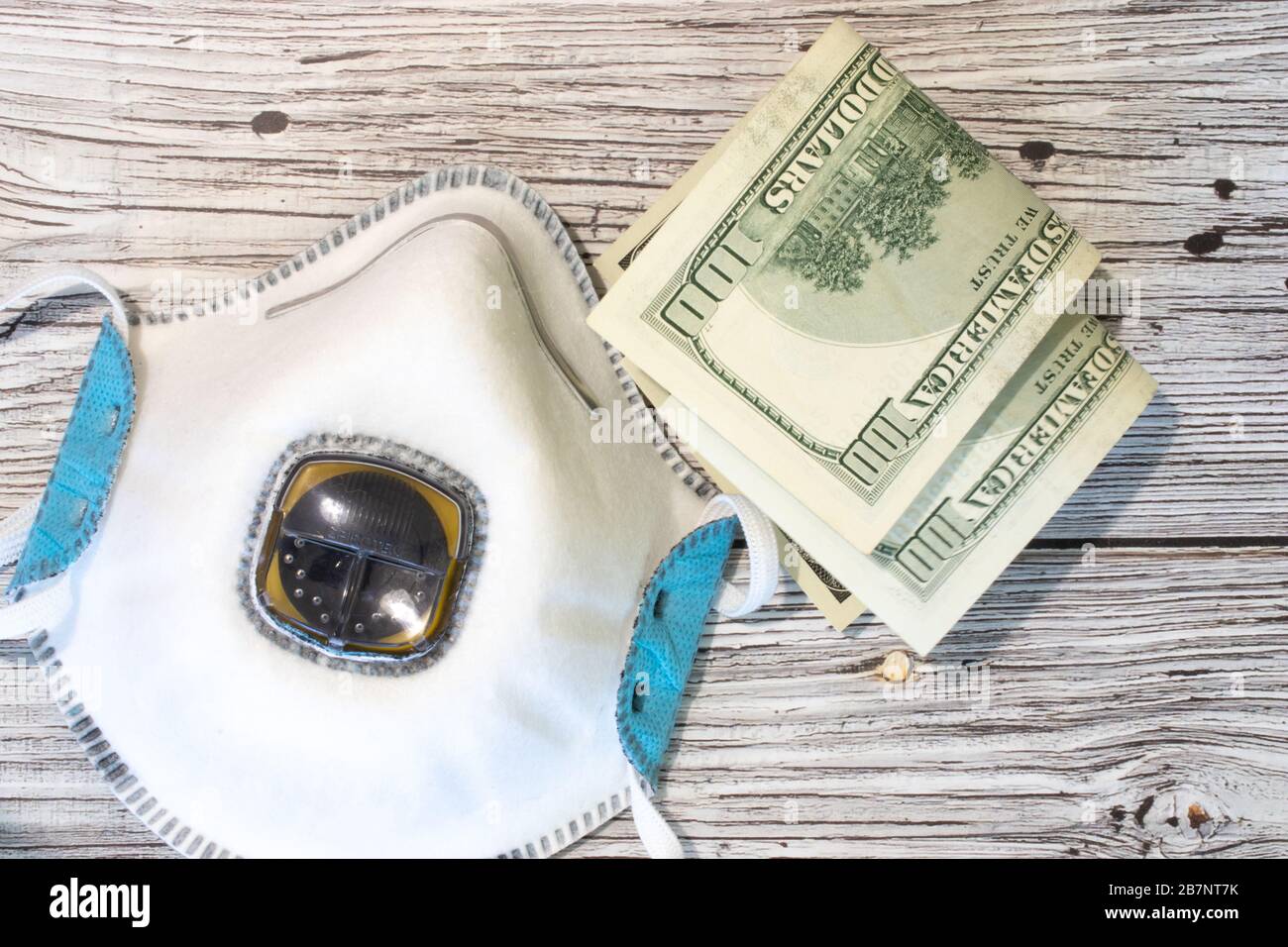 Maschera respiratoria con vista dall'alto banconote in dollari. Concetto di base piatto su denaro, farmaci e assistenza sanitaria Foto Stock