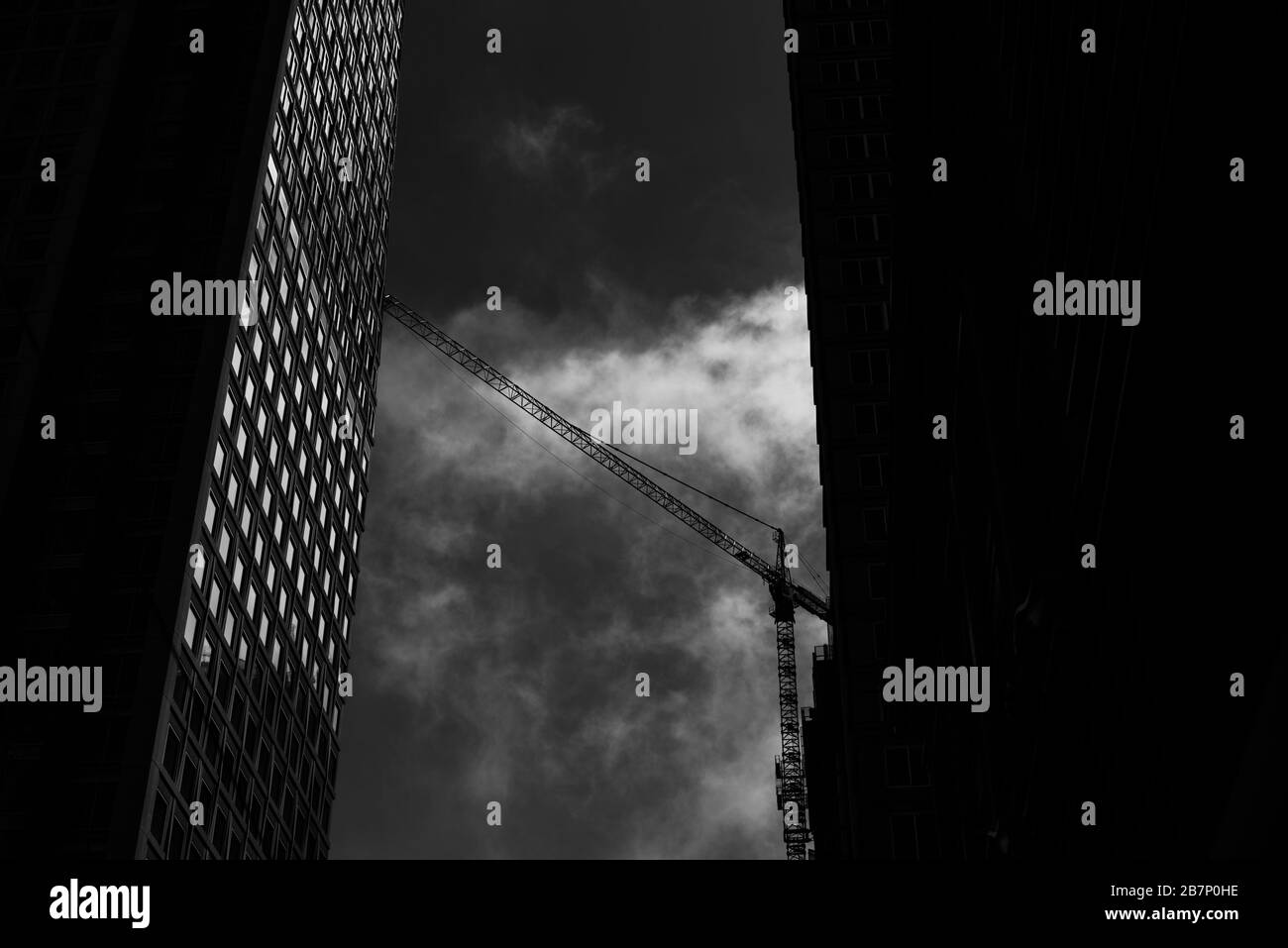 Colpo verticale di grattacieli e una gru a San Francisco Bay Area in bianco e nero Foto Stock