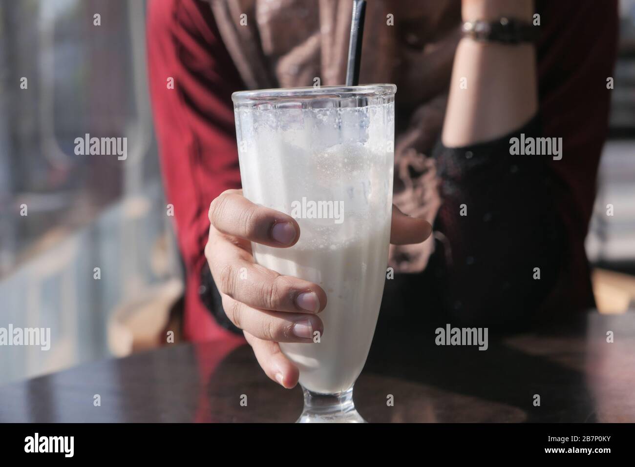 Frullato organico in vetro per mano femmina, primo piano Foto Stock
