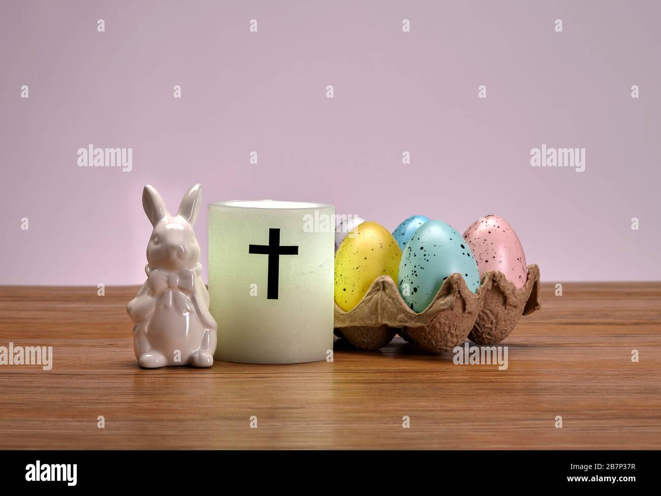 Coniglietto pasquale in ceramica, candela e uova decorate Foto Stock