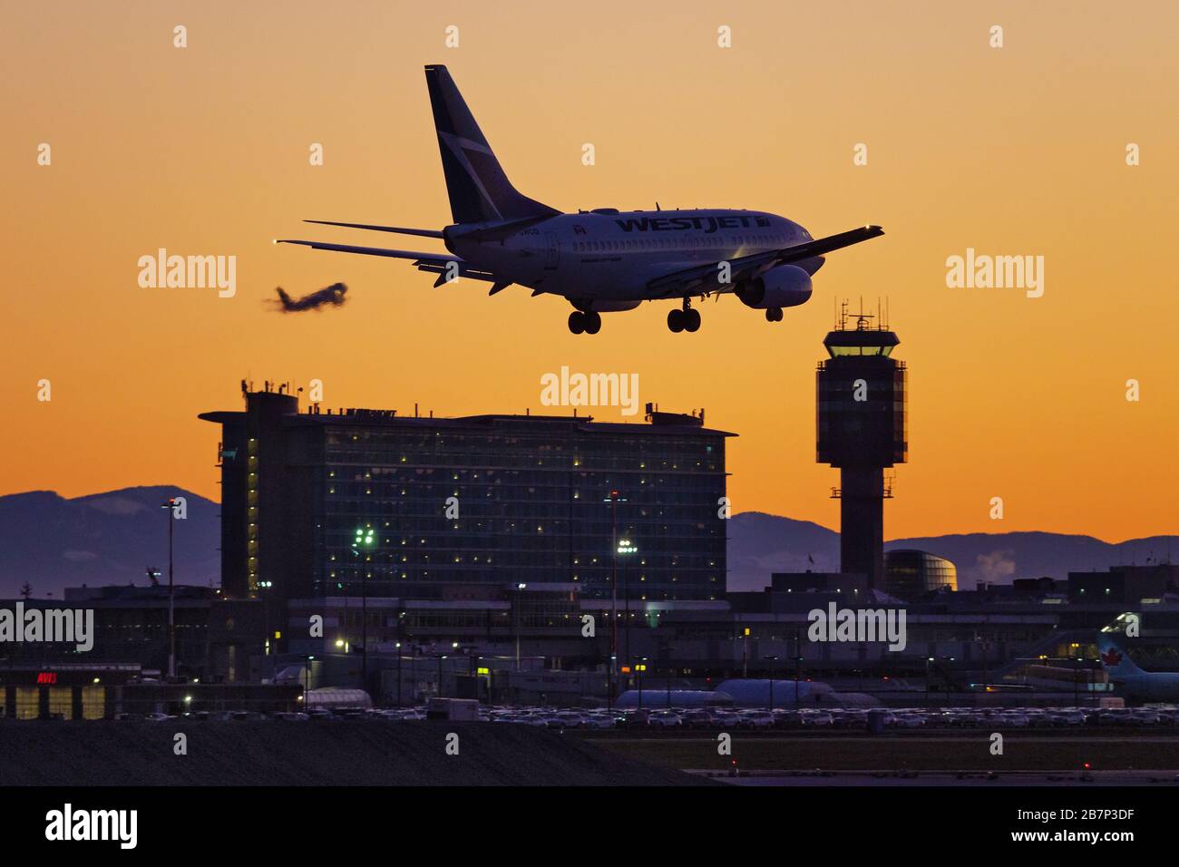 Richmond, British Columbia, Canada. 16 Marzo 2020. Un jet per passeggeri della WestJet Airlines Boeing 737-600 (C-GWCQ) atterra al tramonto, all'aeroporto internazionale di Vancouver, a Richmond. All'inizio del giorno il governo canadese, nel tentativo di fermare la diffusione del romanzo coronavirus, ha annunciato che i confini della nazione sarebbe stato chiuso a partire da mercoledì, a tutti i viaggiatori diversi dai cittadini canadesi e residenti permanenti, cittadini statunitensi, diplomatici e lavoratori essenziali. Credit: Bayne Stanley/ZUMA Wire/Alamy Live News Foto Stock