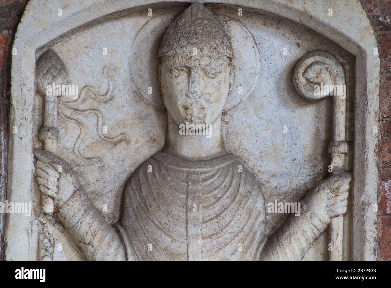 S. Ambrogio con la pastorale e la aspergillum (XII C) - sculture in rilievo - atrio della Basilica di Sant'Ambrogio - Milano Foto Stock