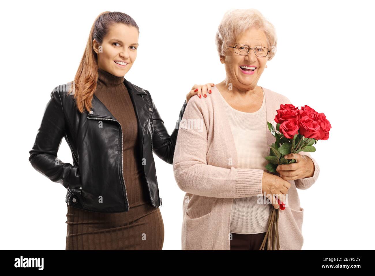 Donna anziana che tiene un mazzo di rose rosse e posa con una giovane donna isolata su sfondo bianco Foto Stock