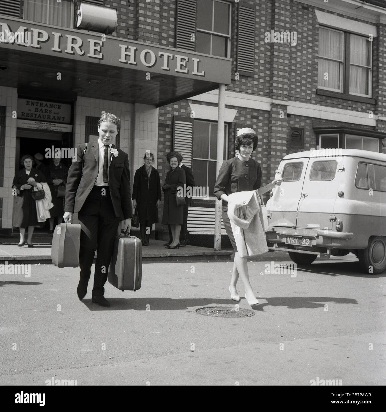 Anni '60, storico, gli ospiti guardano come una giovane coppia appena sposata lasciare il loro Hotel, l'Impero, la mattina dopo il loro matrimonio, Londra, Inghilterra Regno Unito. Foto Stock