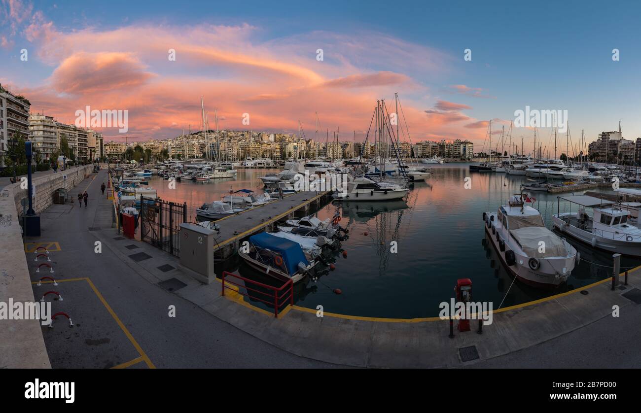 Freattyda, Atene / Grecia - 12 28 2019: Ora d'oro vista panoramica sul porto turistico del Pireo con barche e nuvole rosa Foto Stock