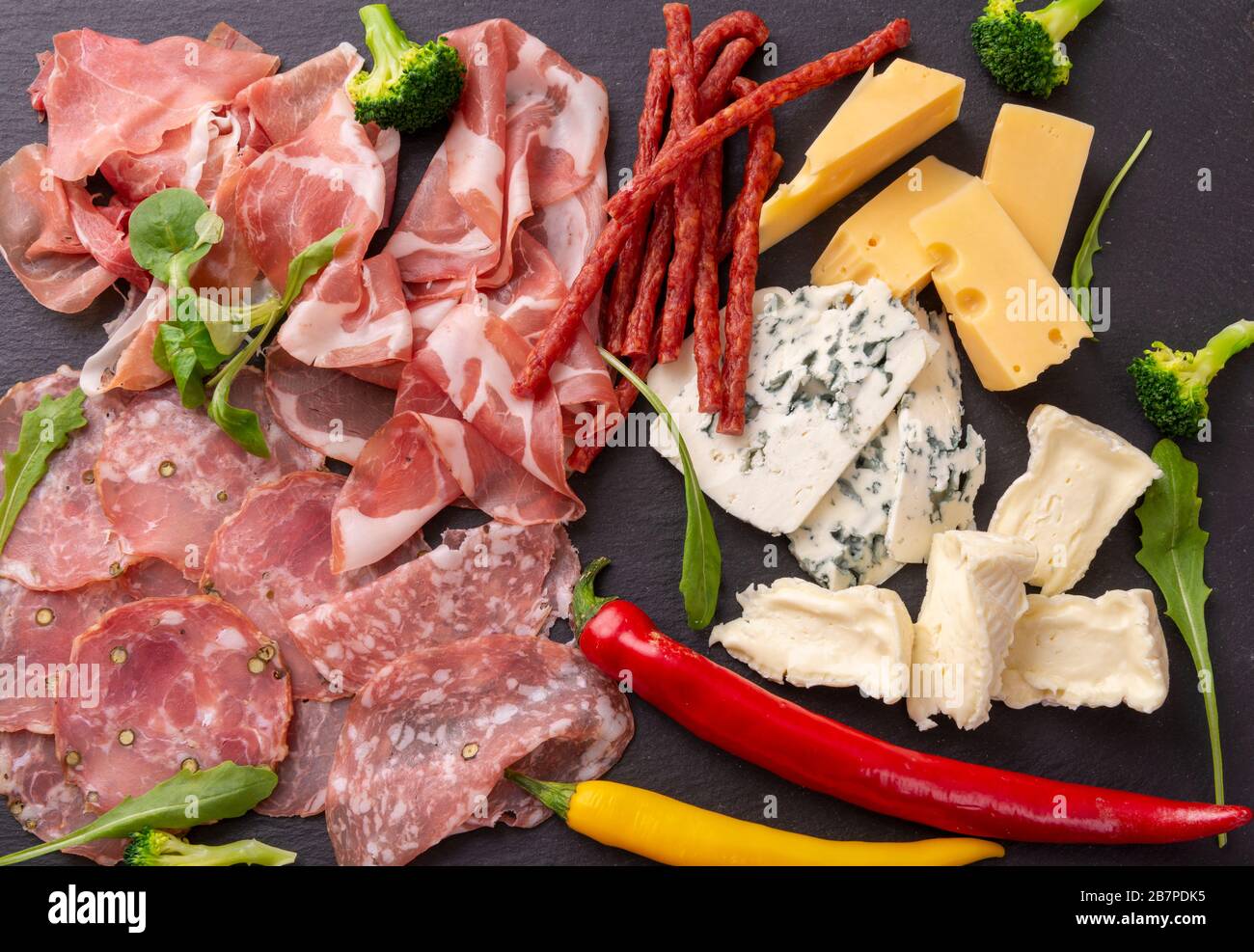 Vari antipasti su un piatto di ardesia. Prosciutto, formaggio e salsiccia. Vista dall'alto Foto Stock