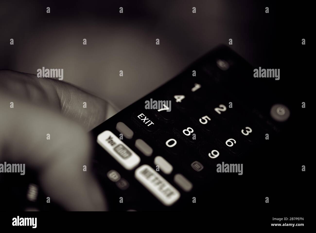 Uomo che tiene il telecomando e guarda la tv. Foto Stock