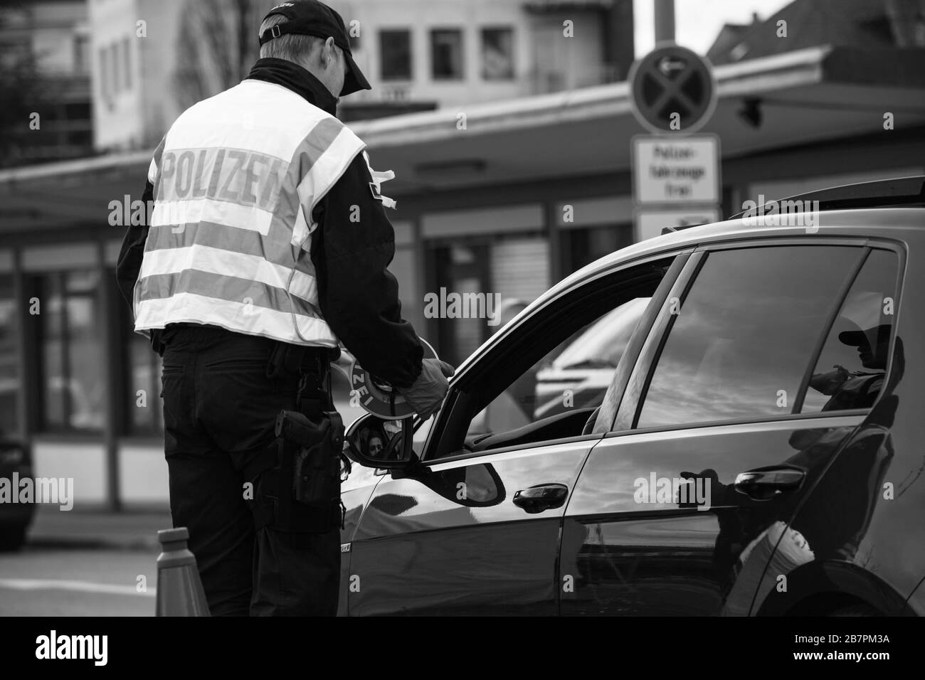 Kehl, Germania - 16 marzo 2020: Vista posteriore dell'ufficiale della polizia federale controlla il traffico al valico di frontiera di Kehl dalla Francia Strasburgo durante le misure di crisi nella lotta contro il coronavirus Foto Stock