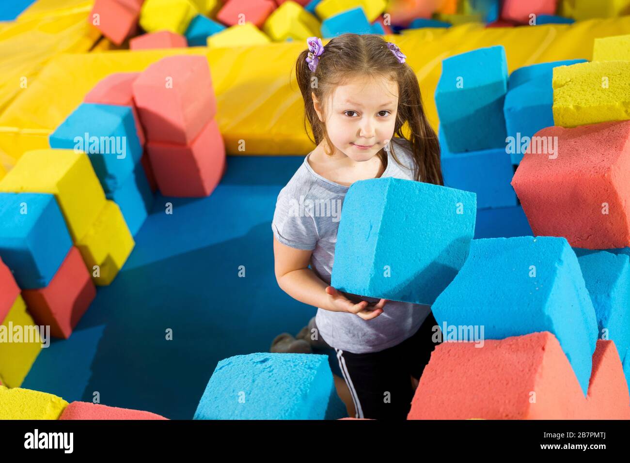 Bambini che giocano con i morbidi cubi nella piscina asciutta nel centro  giochi. Parco giochi con blocchi di gommapiuma nel club dei trampolini Foto  stock - Alamy