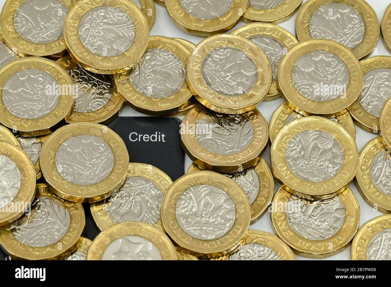 LONDRA, Regno Unito - GENNAIO 2020: Primo piano della valuta britannica Great British Pound GBP - One Pound Coins che circonda l'angolo di una carta di credito Foto Stock
