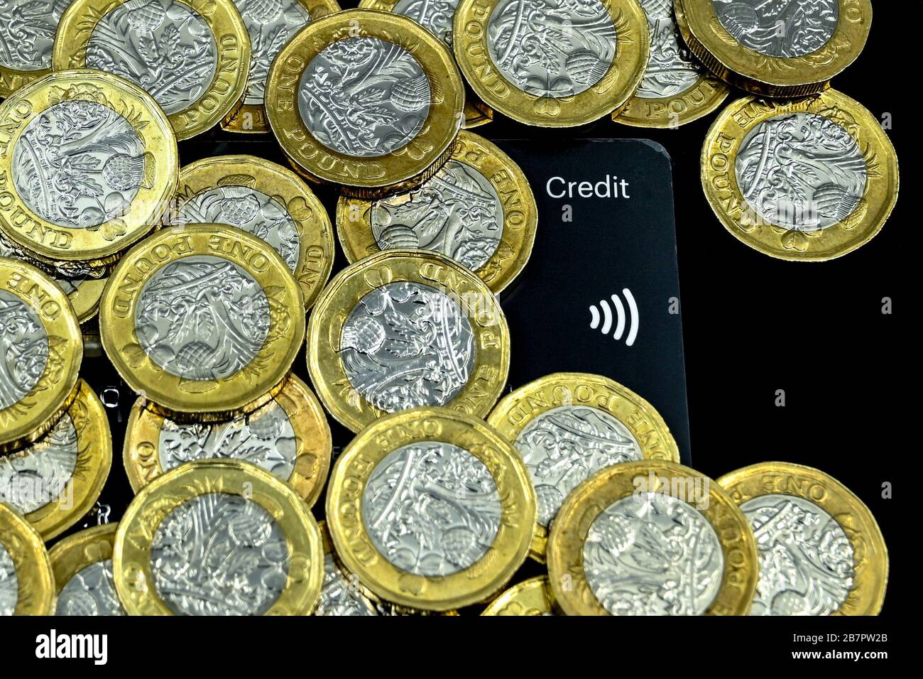 CARDIFF, GALLES - GENNAIO 2020: Primo piano della valuta britannica GBP - una moneta da una libbra sulla carta di credito con un simbolo di pagamento senza contatto Foto Stock