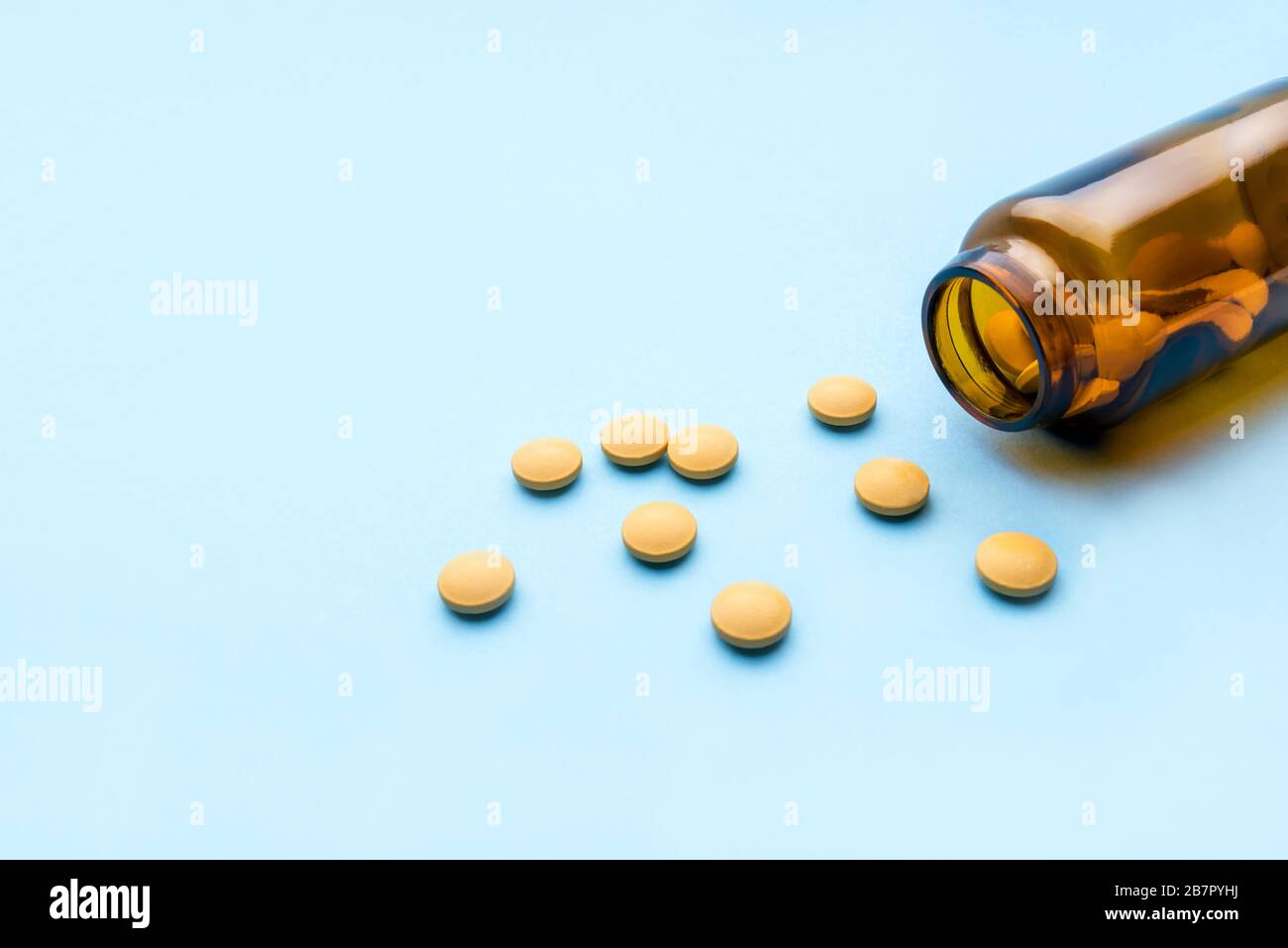Compresse di medicina farmaceutica e flacone su sfondo blu. Foto Stock